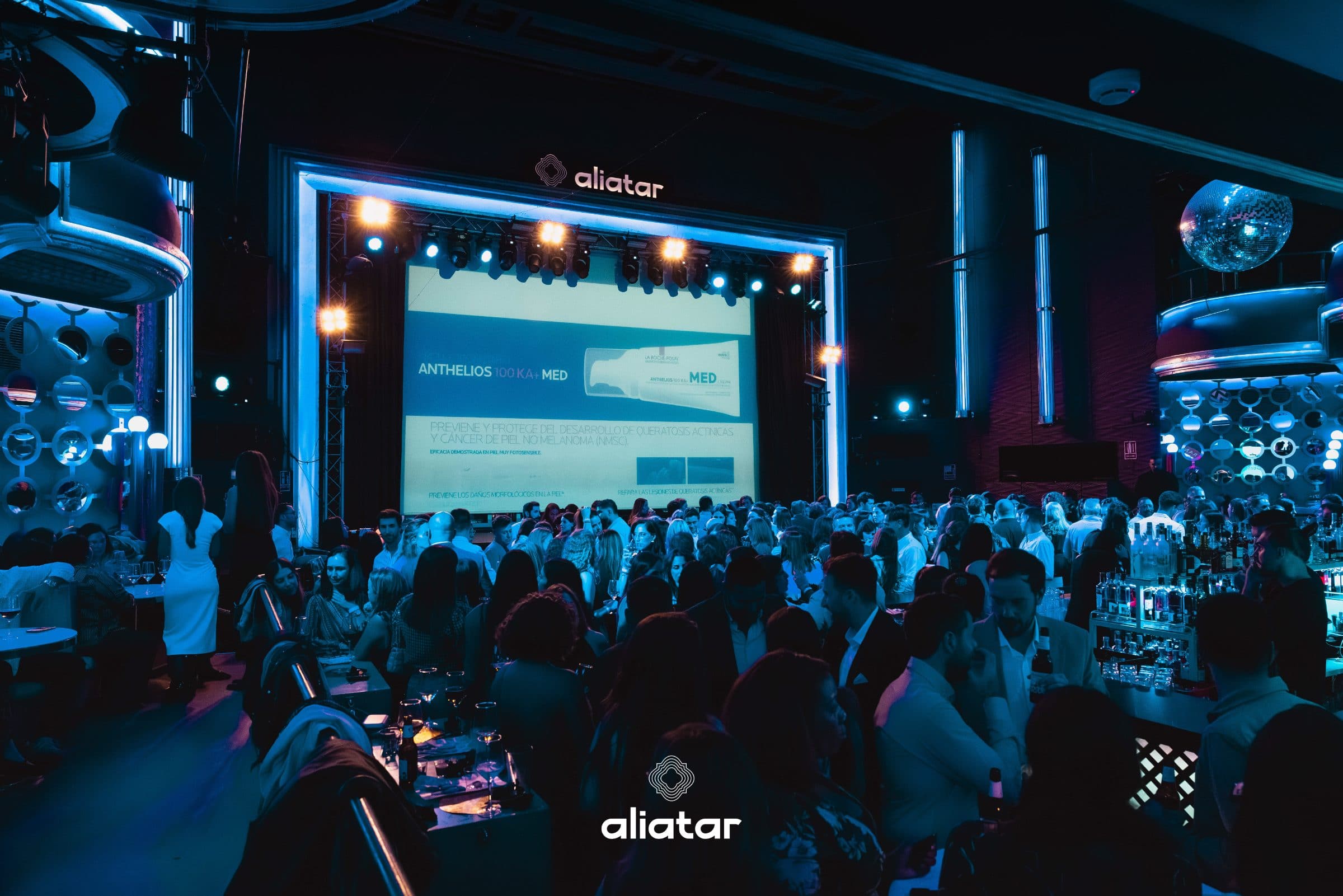 La sala de Aliatar en formato evento corporativo, con pantalla en el escenario y público de pie
