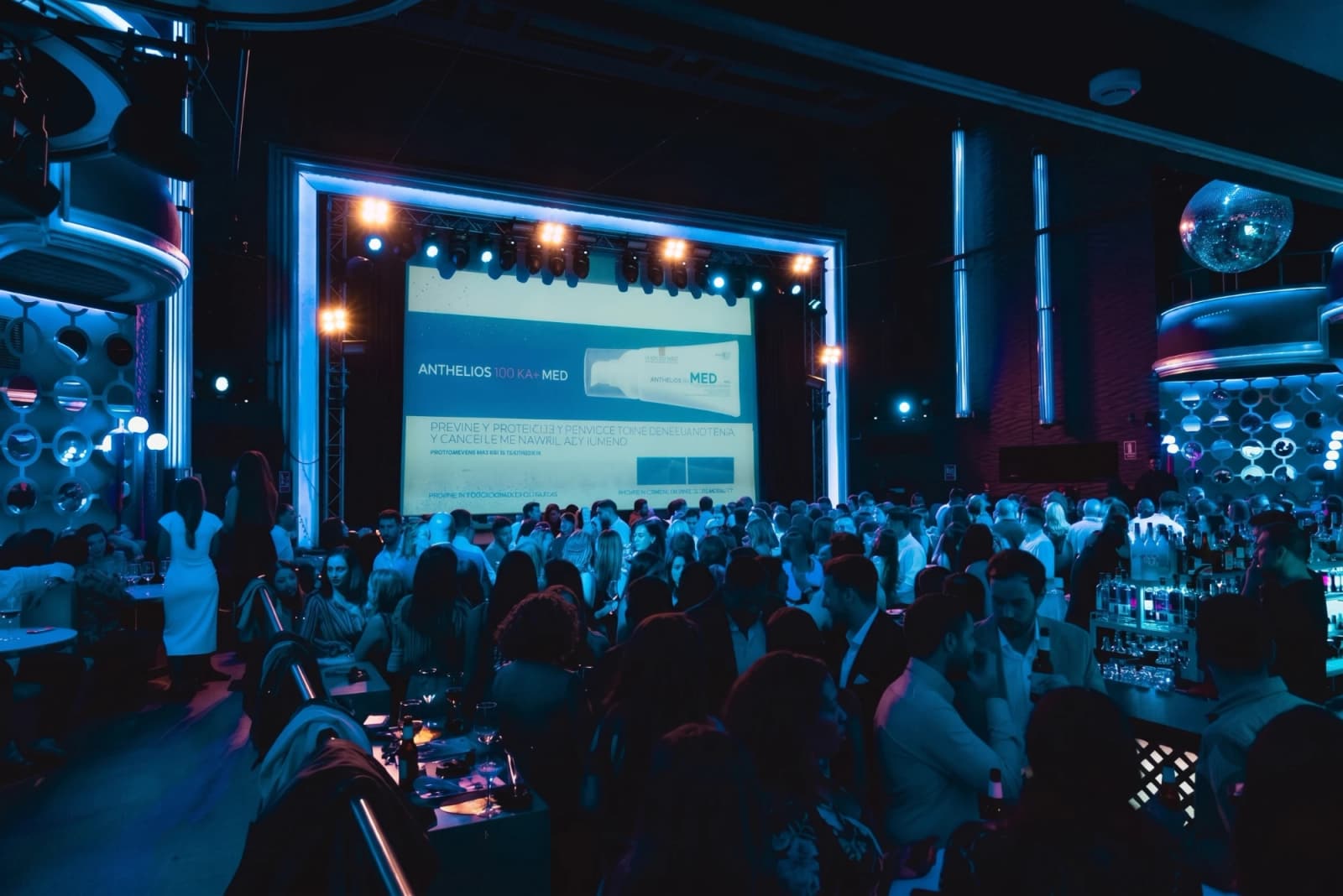 Presentación de empresa en la sala de Aliatar, con pantalla en el escenario y público junto a la barra